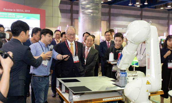 2019 PIS가 8월 30일 호평속에 폐막했다. 한국섬유산업연합회 성기학 회장이 개막 당일 협동로봇 시연 장면을 바라보고 있다.